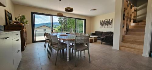 a kitchen and dining room with a table and chairs at Gite Grand Confort en pleine nature - Le Perchoir de l'Olme in Chalmazel Jeansagniere