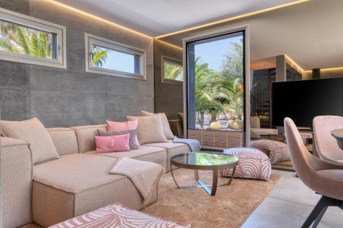 a living room with a couch and a tv at Casita Moritz - Luxury - 1 min to the Beach By Lanzarote Vacation Homes in Costa Teguise