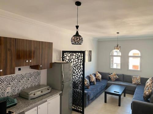 a kitchen and a living room with a blue couch at Residence Pool Beach 5 min in Oued Laou