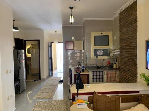 a living room with a couch and a kitchen at منتجع جوليانا الساحل الشمالى , الكيلو65 الساحل الشمالى, طريق اسكندرية-مرسى مطروح , مركز الحمام , محافظة مطروح in Dawwār Muşādif Yūnus