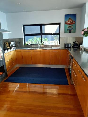a kitchen with a large blue rug on the floor at Ocean Front - Port Kembla in Port Kembla