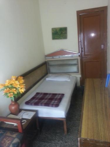 a small room with a bed and a table at Hotel Sun Shine in New Delhi