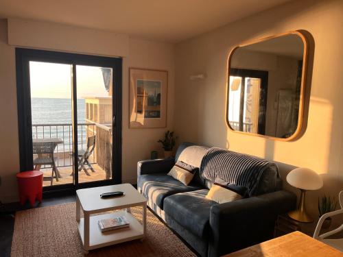 un salon avec un canapé et une vue sur l'océan dans l'établissement Emeraude, pleine vue de mer, à Saint-Malo