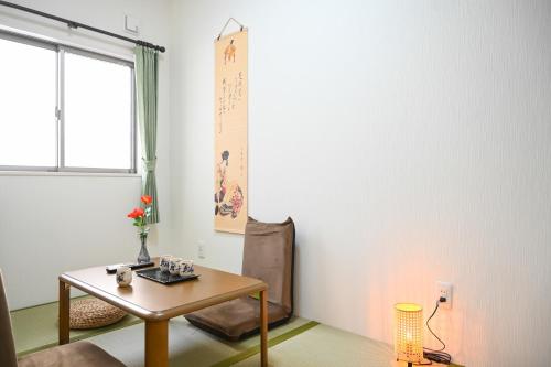 a living room with a table and a window at Umeda Yodogawa Cozy Home 101 步行到JR站5分钟 直达京都神户 大阪梅田1站 新大阪2站 USJ地铁25分钟 in Osaka