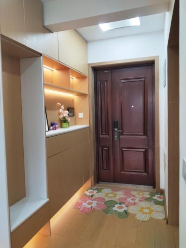 a hallway with a brown door and a flower rug at Whale House in Chongqing