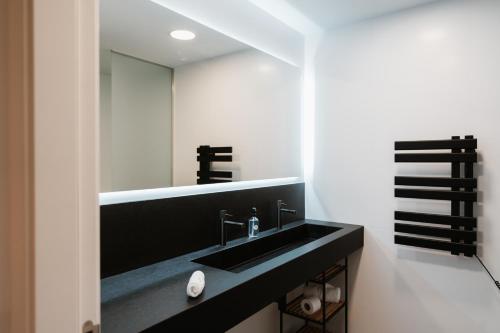 a bathroom with a black sink and a mirror at Apartaments Casa Padró in Manresa