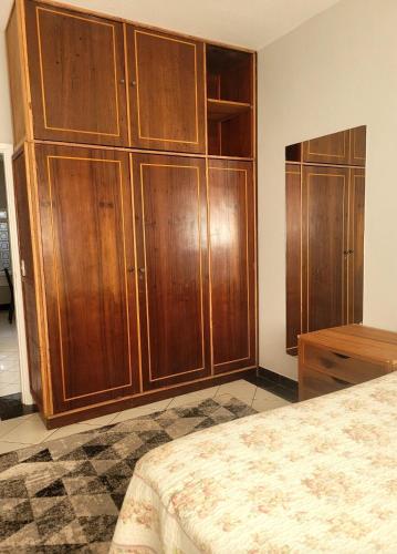 a bedroom with wooden cabinets and a bed at Casa Plenari in Uberaba