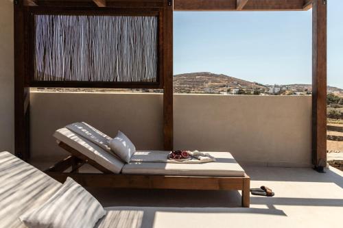 a room with a bed and a table and a window at Ela Tinos in Arnados