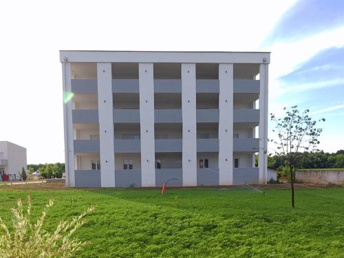 a large white building with a field in front of it at Hotel Doris 