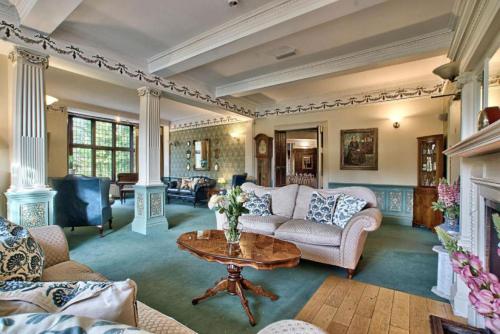 a living room with a couch and a table at Caer Beris Hotel in Builth Wells