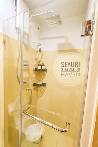 a shower with a glass door in a bathroom at Seyuri Staycation Haven in Manila