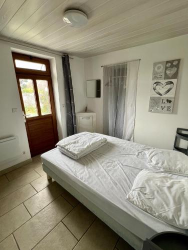 a bedroom with a white bed with a window and a door at Les marins des LYS, Cayeux sur mer, Baie de somme in Cayeux-sur-Mer