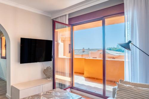 a living room with a sliding glass door to a balcony at Royal Marbella Golf Resort in Estepona