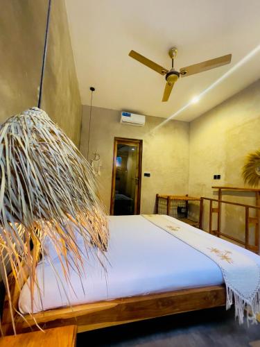a bedroom with a bed with a ceiling fan at The Garten Living in Paje
