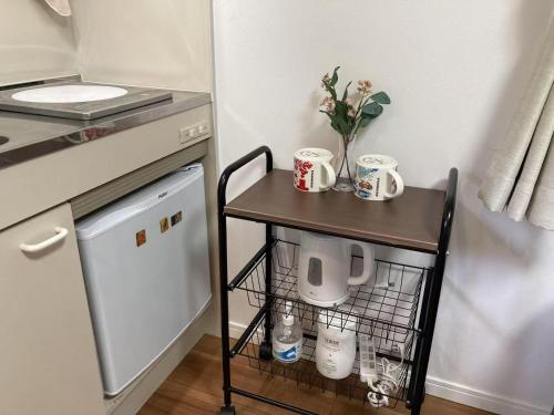 a small table with mugs and flowers on it in a kitchen at 102 山手线近上野一站温馨新公寓 in Tokyo