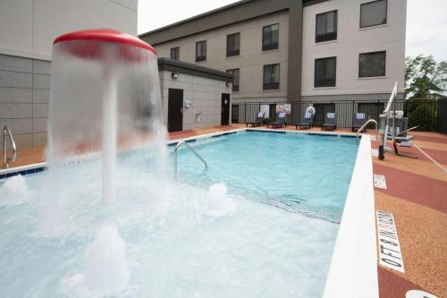 a pool with a fountain in the middle of a building at Four Points by Sheraton Fayetteville Fort Bragg in Fayetteville