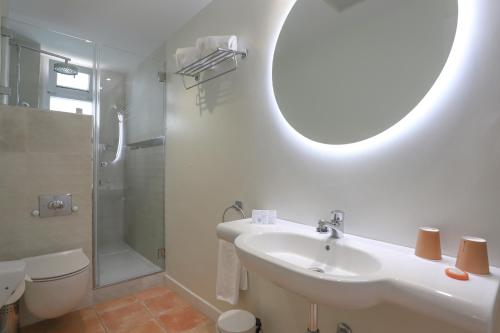 a bathroom with a sink and a toilet and a mirror at Hotel Oasis in Córdoba