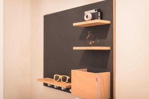a room with wooden shelves with a camera and scissors at Cozy home in the heart of Athens in Athens