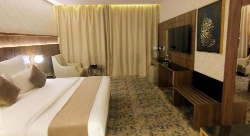a hotel room with a large bed and a television at فندق سما المدينة in Al Madinah
