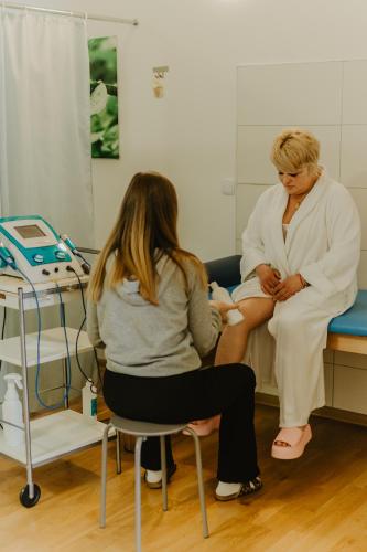 two women sitting on a bed in a hospital room at Hotel Cieplice MEDI & SPA in Jelenia Góra