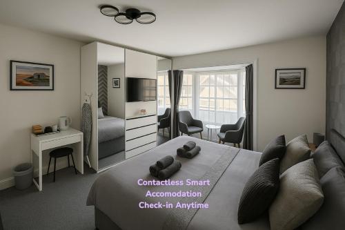 a bedroom with a bed and a room with a tv at Great Georges Retreat Central Weymouth Beach Contactless Smart Accommodation in Weymouth