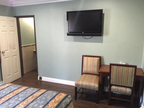 Habitación de hotel con cama y TV en la pared en Park Motel en Los Ángeles