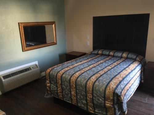 a bedroom with a bed and a mirror and a fan at Park Motel in Los Angeles