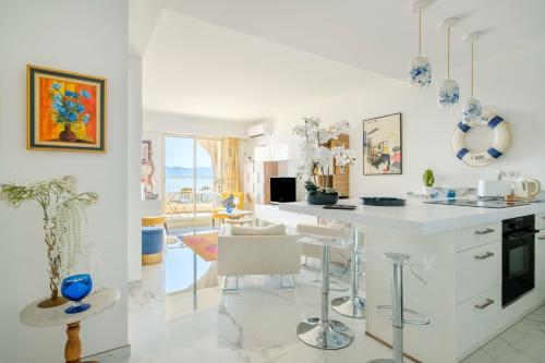 une cuisine blanche avec un comptoir et une salle à manger dans l'établissement Palais Isabelle, à Cannes