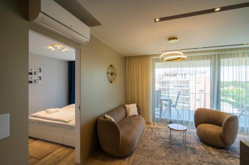 a bedroom with a bed and a couch and a chair at MyFlat Coral 61 Luxury Apartment in Siófok