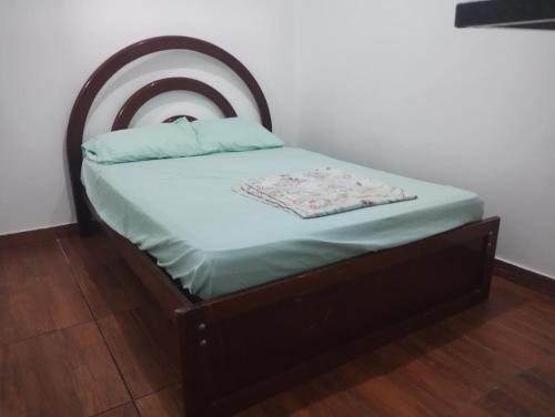 a small bed with a wooden headboard in a room at Apartamento tipo Studio a 5 Minutos de carro do Centro in Caruaru