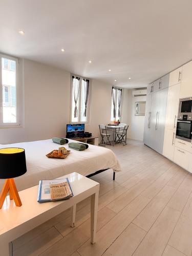 Cette grande chambre comprend un lit et une table. dans l'établissement Le Clemenceau By ApiRent #Cosy #200m des plages #Wifi, à Cannes