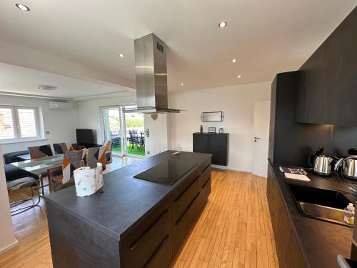 - une cuisine avec un grand comptoir noir dans la chambre dans l'établissement Gite de la chapelle-Le hibou, à Innenheim