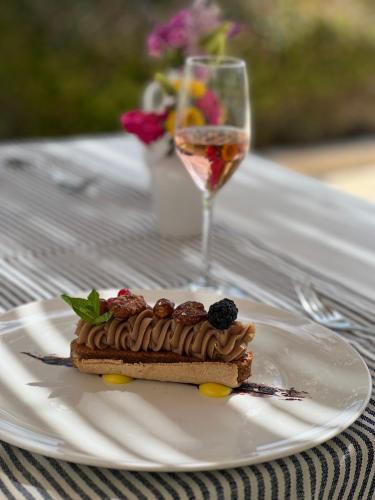 a piece of cake on a plate with a glass of wine at Hotel Residence Il Porto in Mattinata