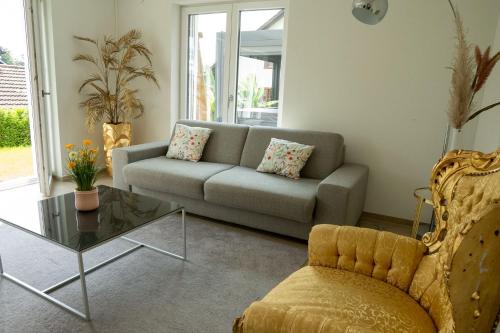 a living room with a couch and a glass table at Star's Apartment in Böttstein