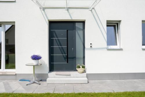 a black door on the side of a white house at Star's Apartment in Böttstein