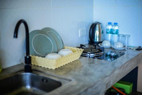 a kitchen sink with plates in a basket next to a counter at Sairee View Resort in Koh Tao