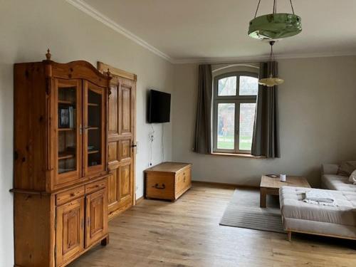 een woonkamer met een bank en een grote houten kast bij Kaiserhof Schwennenz in Grambow