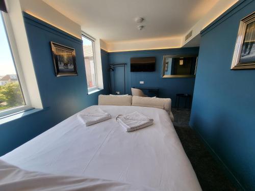 a bedroom with a large white bed with blue walls at 272-274 Accommodation AT in Blackpool