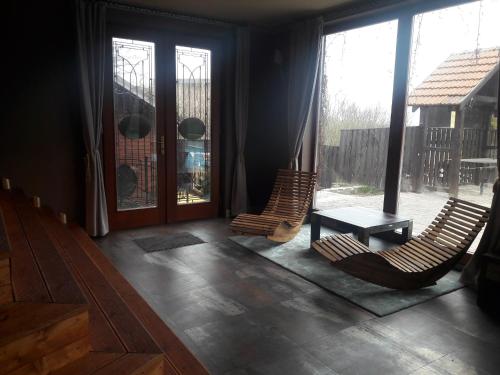 two chairs and a table in a room with windows at Areal Botanika in Unhošť