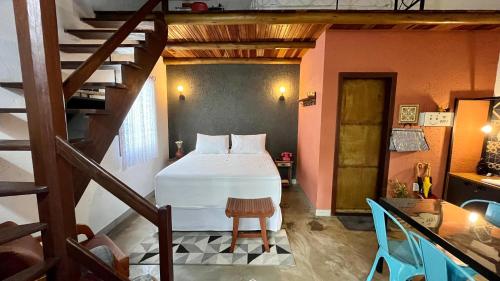 a bedroom with a bed in a room with a staircase at Chalés Calima in Lençóis