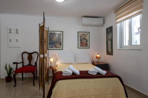 a bedroom with a bed and a red chair at Myrto lower ground floor studio in Kalamata
