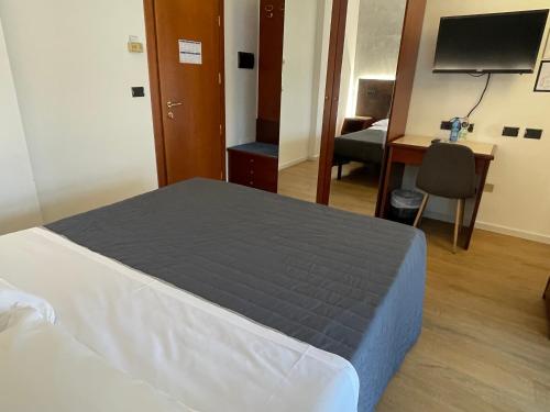 a bedroom with a bed and a desk and a computer at Hotel Sirena - B&B in Cesenatico