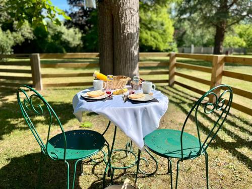 a table with plates of food and a basket of food at Le dôme en seine, proche Giverny in Moisson