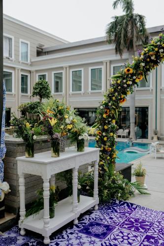 an arch with flowers on a table next to a pool at The Tivoli New Delhi in New Delhi
