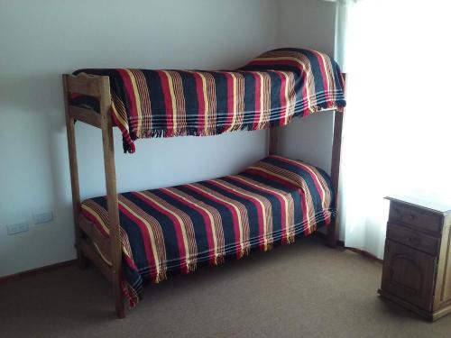 Litera con asiento a rayas en una habitación en Complejo Las Cortaderas, en San Rafael