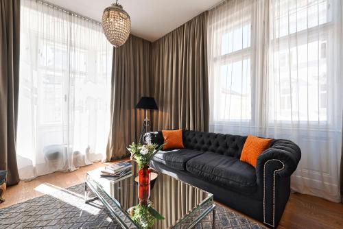 a living room with a black couch and a glass table at 6 rooms in Vienna