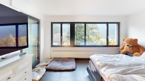 a teddy bear sitting on a bed in a bedroom at Insane Villa in the nature in Silenen