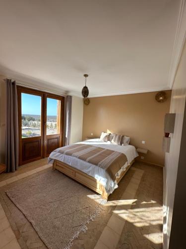 a bedroom with a large bed and a large window at Villa Sakina Essaouira in Ounagha