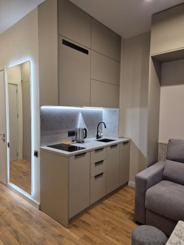a kitchen with a sink and a couch in a room at Mayak Bamboo Beach Tsikhisdziri in K'obulet'i