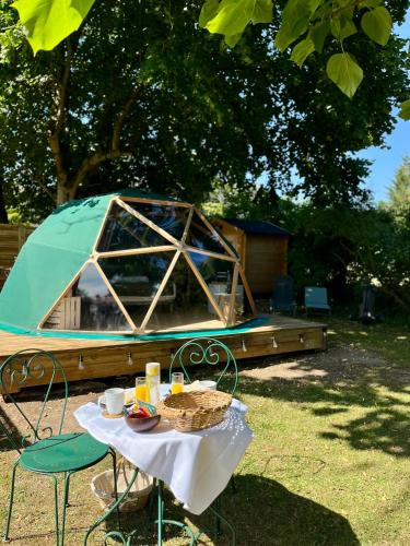 a table with a plate of food and a tent at Le dôme en seine, proche Giverny in Moisson